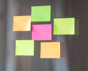 Close-up of sticky multicolored notes on a glass wall in the office. Horizontal photo.