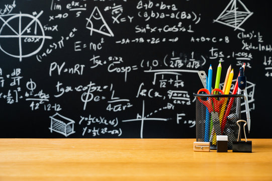 Education background concept. Stationery in holder color pencil, compasses tool, scissors, rulers, sharpener On chalkboard with the Mathematical formula background.