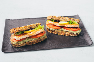 tasty salmon sandwiches served on plate
