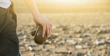 Man with empty flask in the desert. Drought and water scarcity caused by global warming