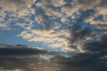 Fototapeta na wymiar fondo naturaleza con cielo azul y nubes blancas y negras al atardecer