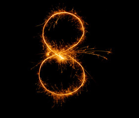 number eight written with a sparkler on a black background