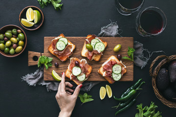 Crusty toasts with prosciutto served with wine
