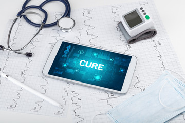 Tablet pc and medical stuff with CURE inscription, prevention concept