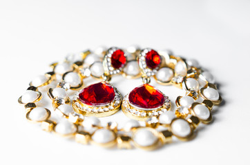 Close-up view of   woman bracelet and earrings jewelry on white background .