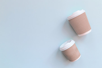 Fototapeta na wymiar Paper cups of coffee to go on pastel background.
