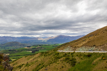 Fototapeta premium The road among the hills and mountain peaks of the South Island. Queenstown neighborhood. New Zealand