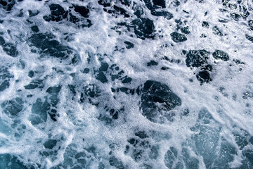 Top down aerial view of sea water surface. White foam waves texture as natural background.