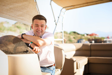 man helm boat on pier. tours on water