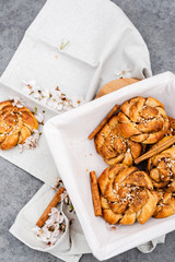 Top view of a basket with cinnamon rolls on a gray background.