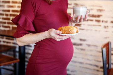 Pregnant woman enjoying herself in a cafe