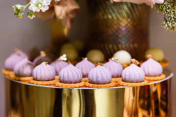 Pink pastries on a gold stand. Buffet table.