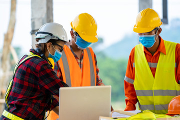 Engineer wearing protective mask to Protect Against Covid-19 working at construction site,Architect...