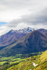 Steep banks along the shores of Lake Wakatipu. Snow caps of the mountains. South Island, New Zealand