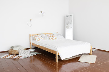 The interior of the bedroom. A spacious, bright, fresh bedroom with white walls and wooden floor,...