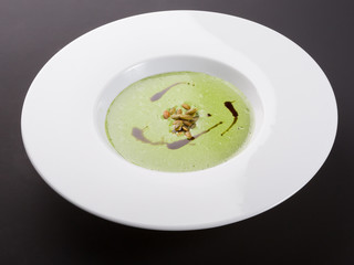 Green cream soup in white bowl
