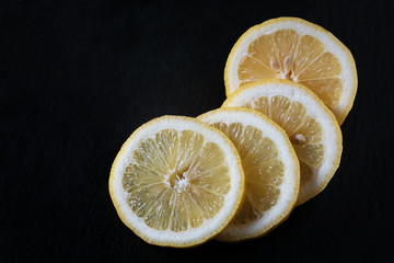 round slices of lemon on a black background