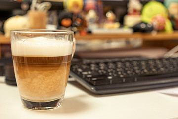 A cup of coffee with milk on Filtered image : A cup of coffee with milk on the table in officethe table in office