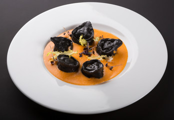 Black ravioli pasta with orange sauce