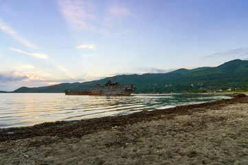 Old ship aground in the bay. Old rusty ship aground in the bay at sunset. Peninsula of gamas. Far East. Russia.