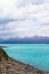 Mountains over turquoise water. The mountainous shores of Lake Pukaki. New Zealand