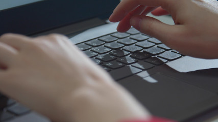 Woman freelancer typing on a keyboard. Close-up