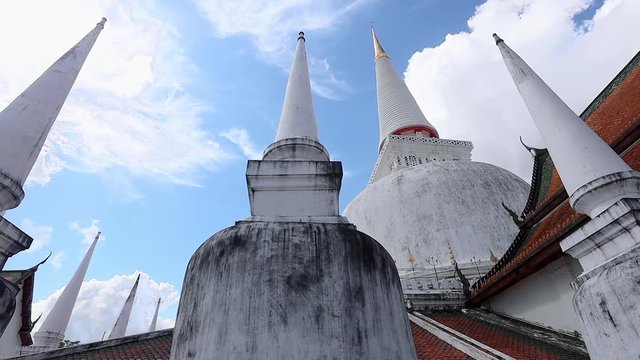 elegant pagodas of  Wat Phra Mahathat Woramahawihan. The main Buddhist temple of Nakhon Si Thammarat Province in southern Thailand. The main stupa of the temple, Phra Borommathat Chedi. Blue sky day.