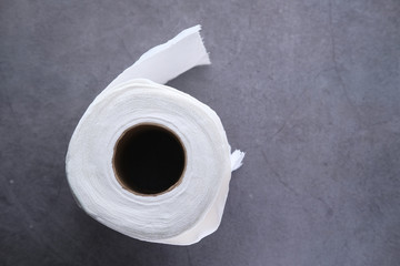 roll of toilet paper on gray background 