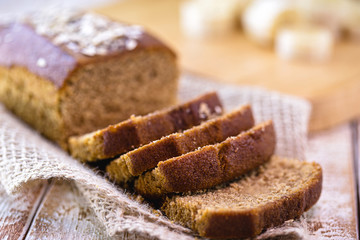 Gluten-free vegan bread and no animal products. Vegetarian bread with oatmeal, banana flavor, on a white rustic table, sliced ​​and ready to serve.