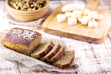 Gluten-free vegan bread and no animal products. Vegetarian bread with oatmeal, banana flavor, on a white rustic table, sliced ​​and ready to serve.