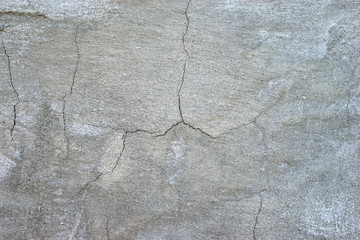 The cracked surface of the plastered wall of the house