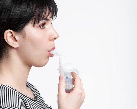 profile picture of brunette woman using inhaler. patient inhale medicine