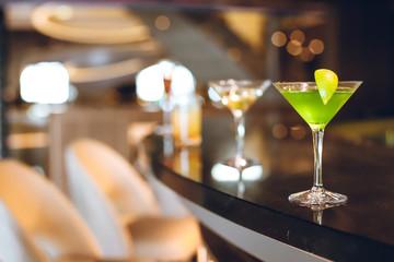 Lush green cocktail on the bar stand in a restaurant. Close up. Indoor shot.