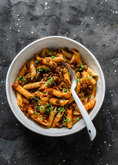 Vegetarian lentil Bolognese sauce penne pasta on a dark background, top view. Healthy eating concept