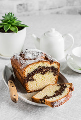 Cozy tea table - homemade cake with nuts and chocolate, teapot, cup, succulent flower on the kitchen table
