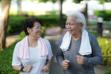 
Senior couples playing outdoor sports, jogging on forest roads in the park in the morning.