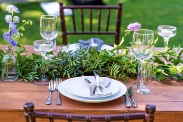 Preparing for an open-air party. Decorated with fresh flowers served tables. Table number. Decoration Details