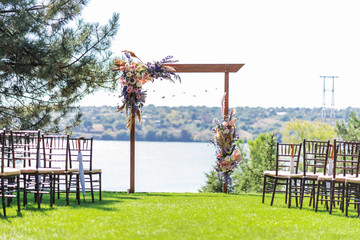 A beautiful venue for an open-air wedding ceremony. Wedding arch and rows of guest chairs on a...