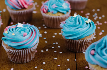 Pink and blue cupcakes on a natural wooden background