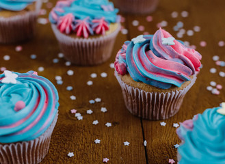 Pink and blue cupcakes on a natural wooden background