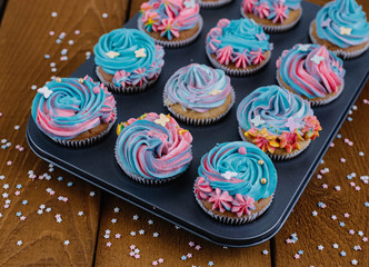 Colored cupcakes on a wooden background in a baking dish