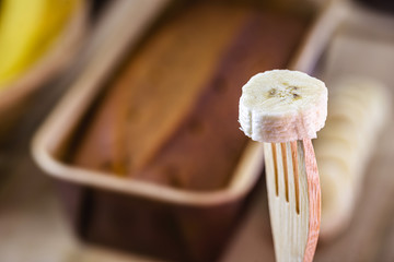 banana slice in recyclable wood graph. Banana cake in the defocused background.