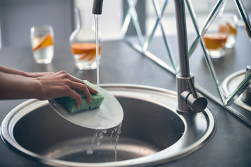 Young woman working and cleaning kitchen indoors