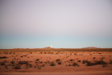 Fototapeta na wymiar Moon rising over desert mountains