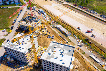 Aerial Bird Eye View Of a Construction Site Building Cranes Looking Down Industrial Machinery Area around Residential Urban Apartments