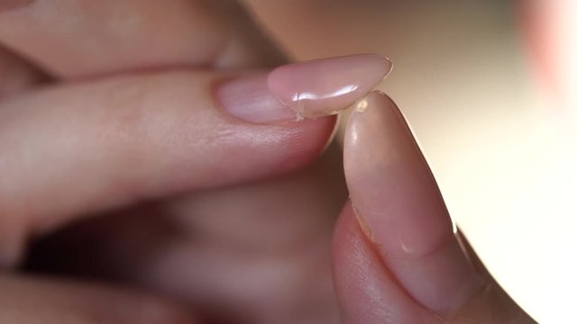 Closeup view 4k video of broken nail of woman with old worn manicure during period of staying home because of quarantine time.
