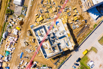 Obraz premium Widok z lotu ptaka żurawia do podnoszenia wieży i betonowej ramy wysokiego budynku mieszkalnego w budowie w mieście. Koncepcja rozwoju miast i wzrostu nieruchomości.