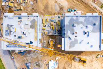 Construction site with cranes. Construction workers are building. Aerial view apartment building construction, cranes on sunset background
