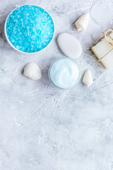 Fototapeta na wymiar blue set for bath with salt and shells stone background top view mock up