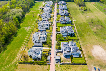 Aerial view of residential houses neighborhood and apartment building complex at sunset. Tightly...